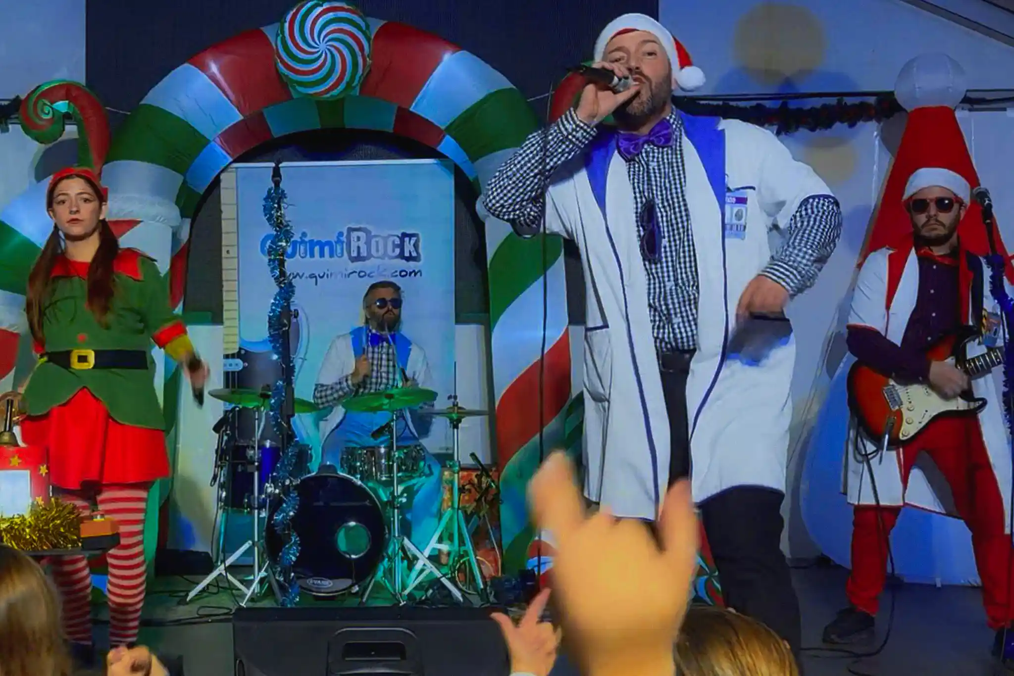 Niños y niñas levantando las manos y participando durante el espectáculo musical infantil “Mi Plan de Navidad”